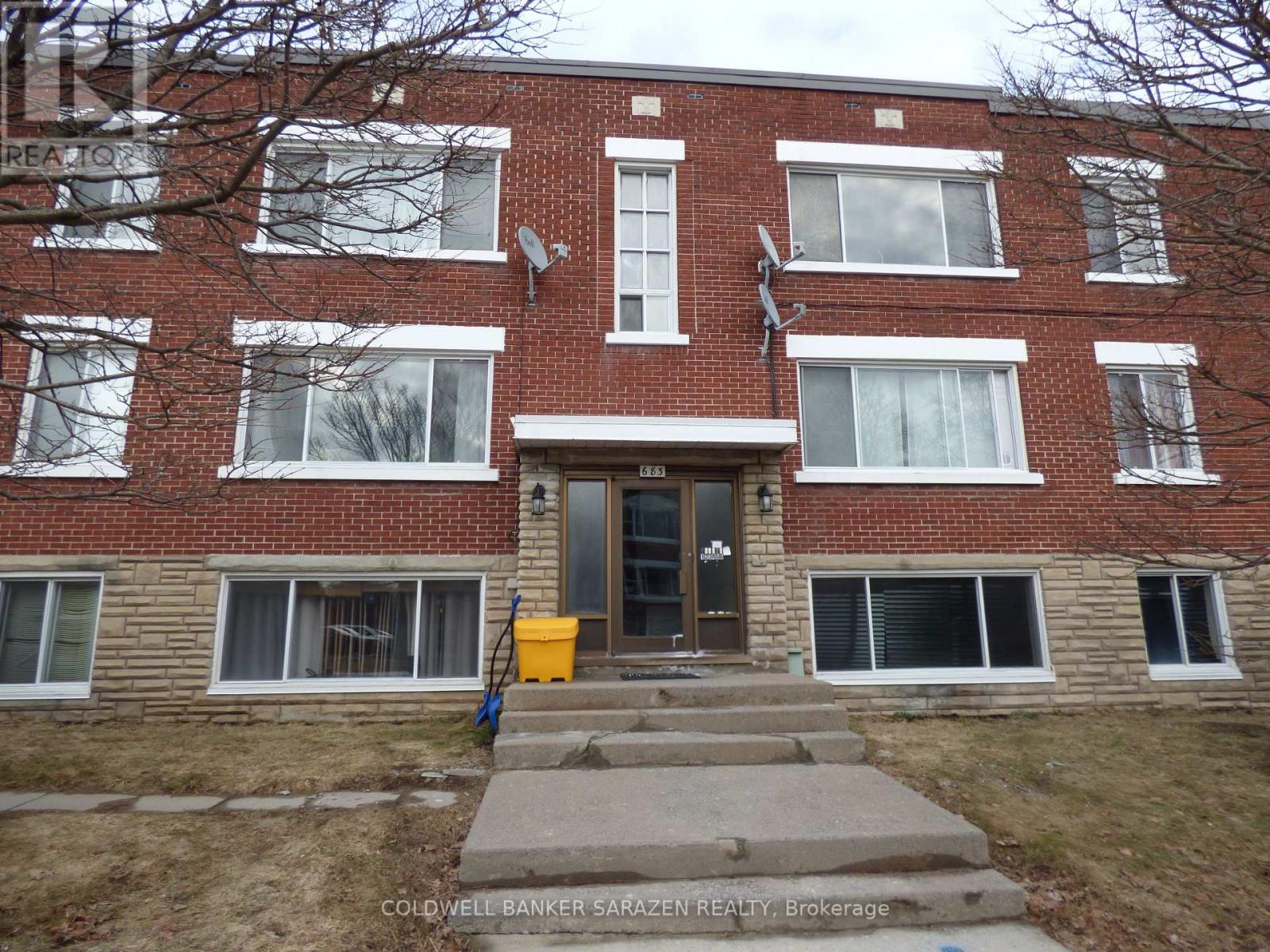 A brick building with a front door and steps leading up to it.