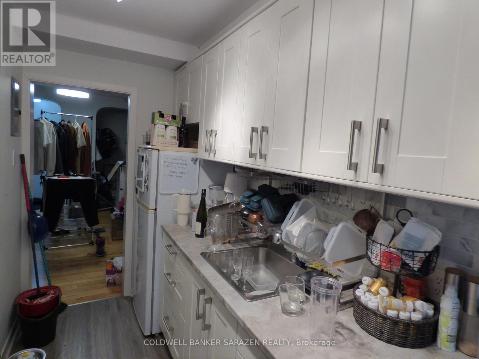 A kitchen with white cabinets and a sink.