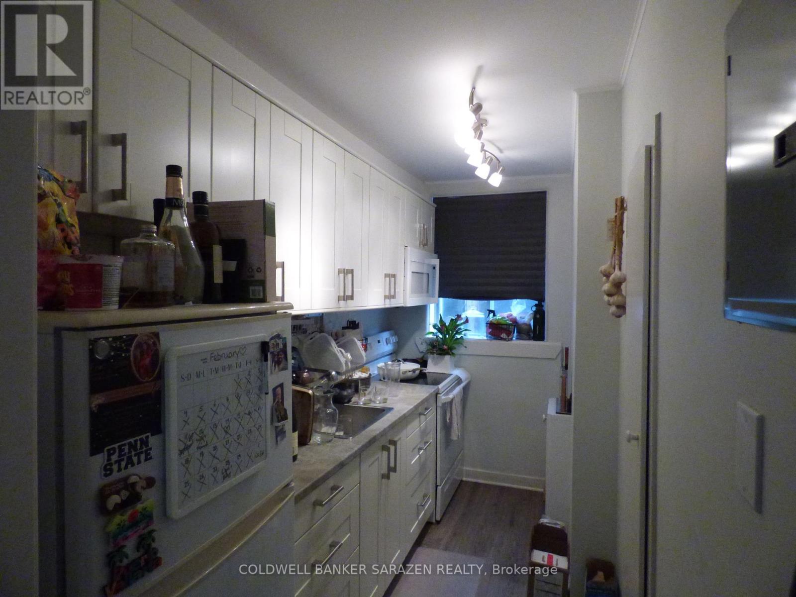 A kitchen with white cabinets and a Penn State refrigerator magnet.
