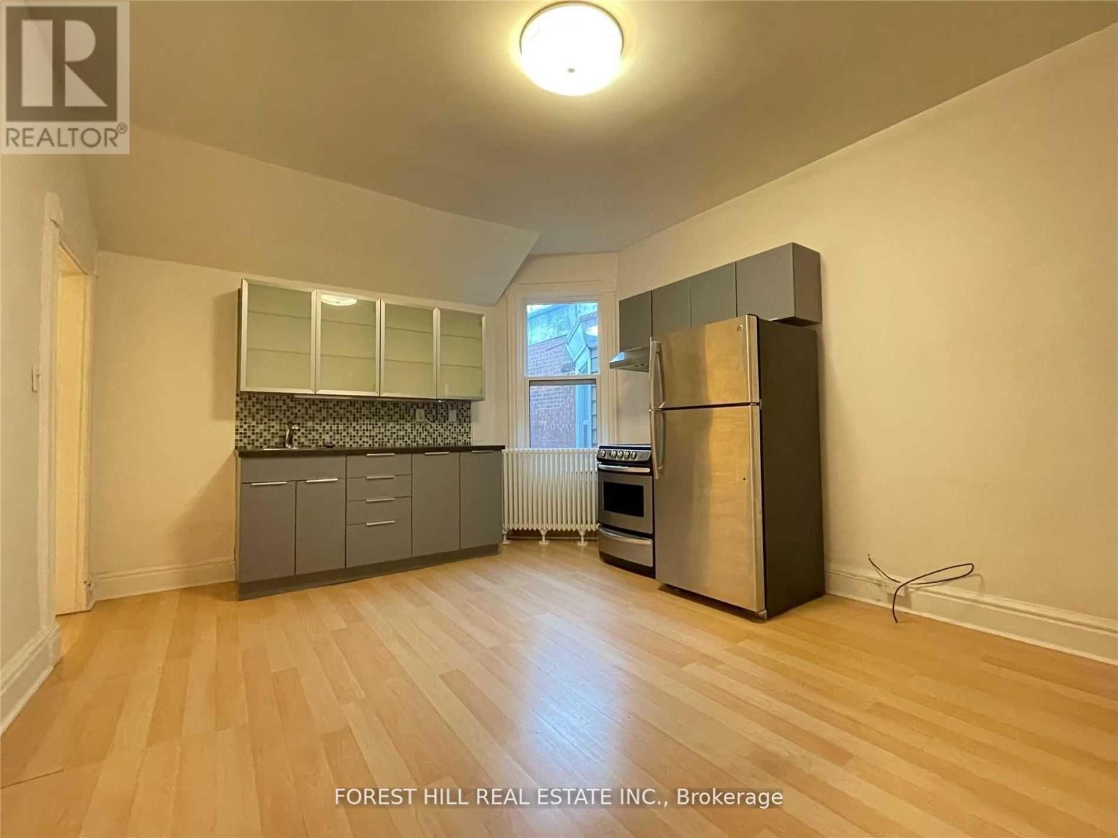A spacious kitchen with wooden floors and a large island.