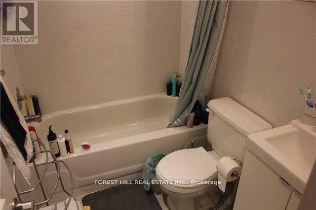 A bathroom with a white toilet, a white sink, and a white bathtub.