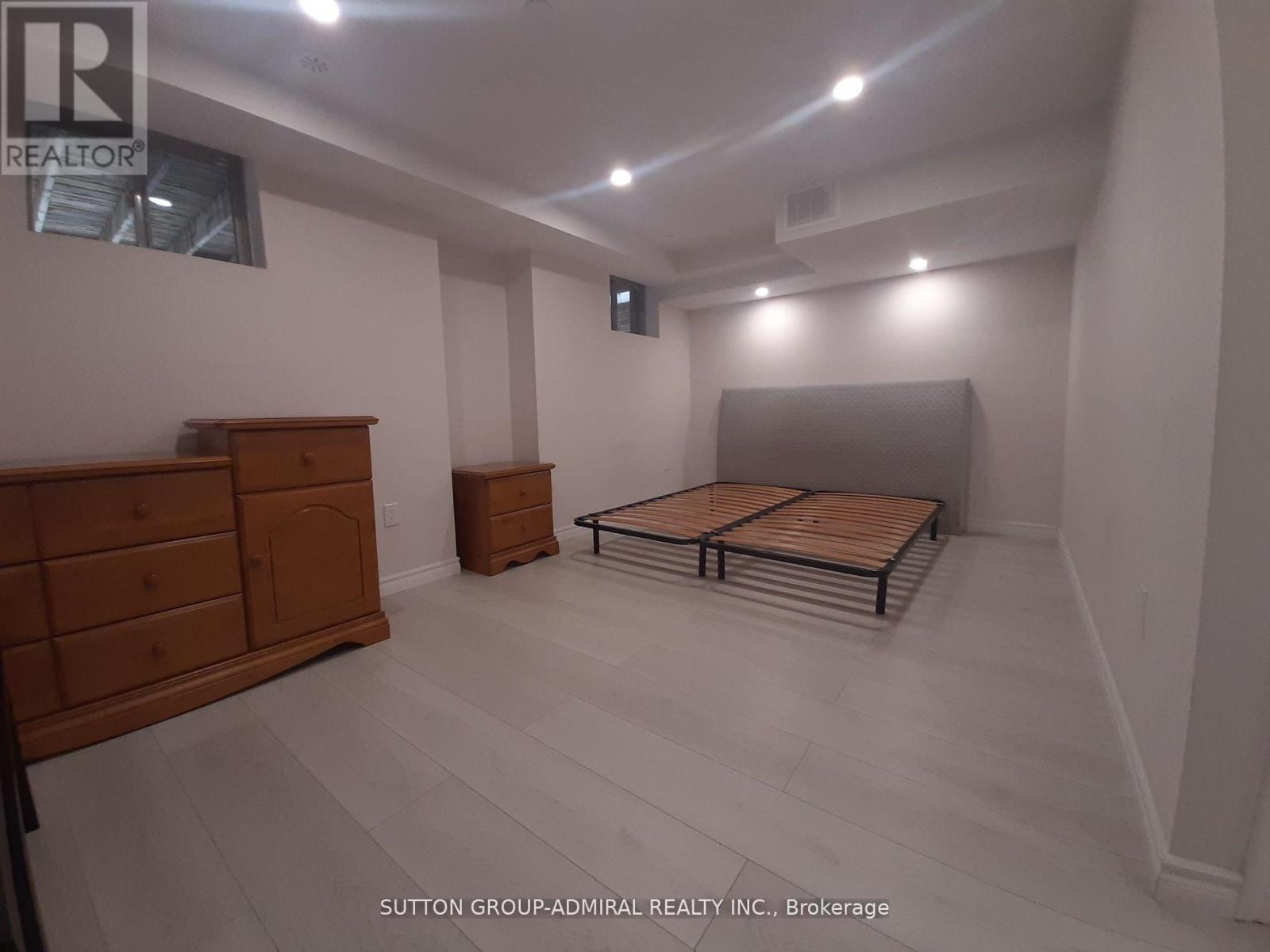 A bedroom with a bed, dresser, and mirror.