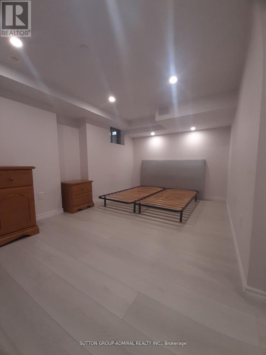A bedroom with a bed, nightstand, and dresser.