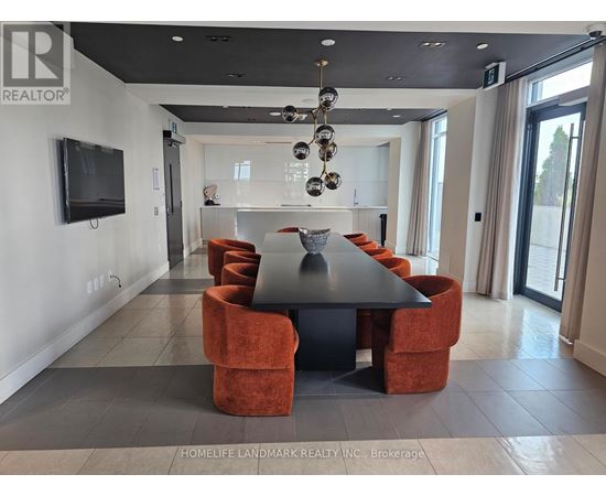 A modern dining room with a black table and orange chairs.