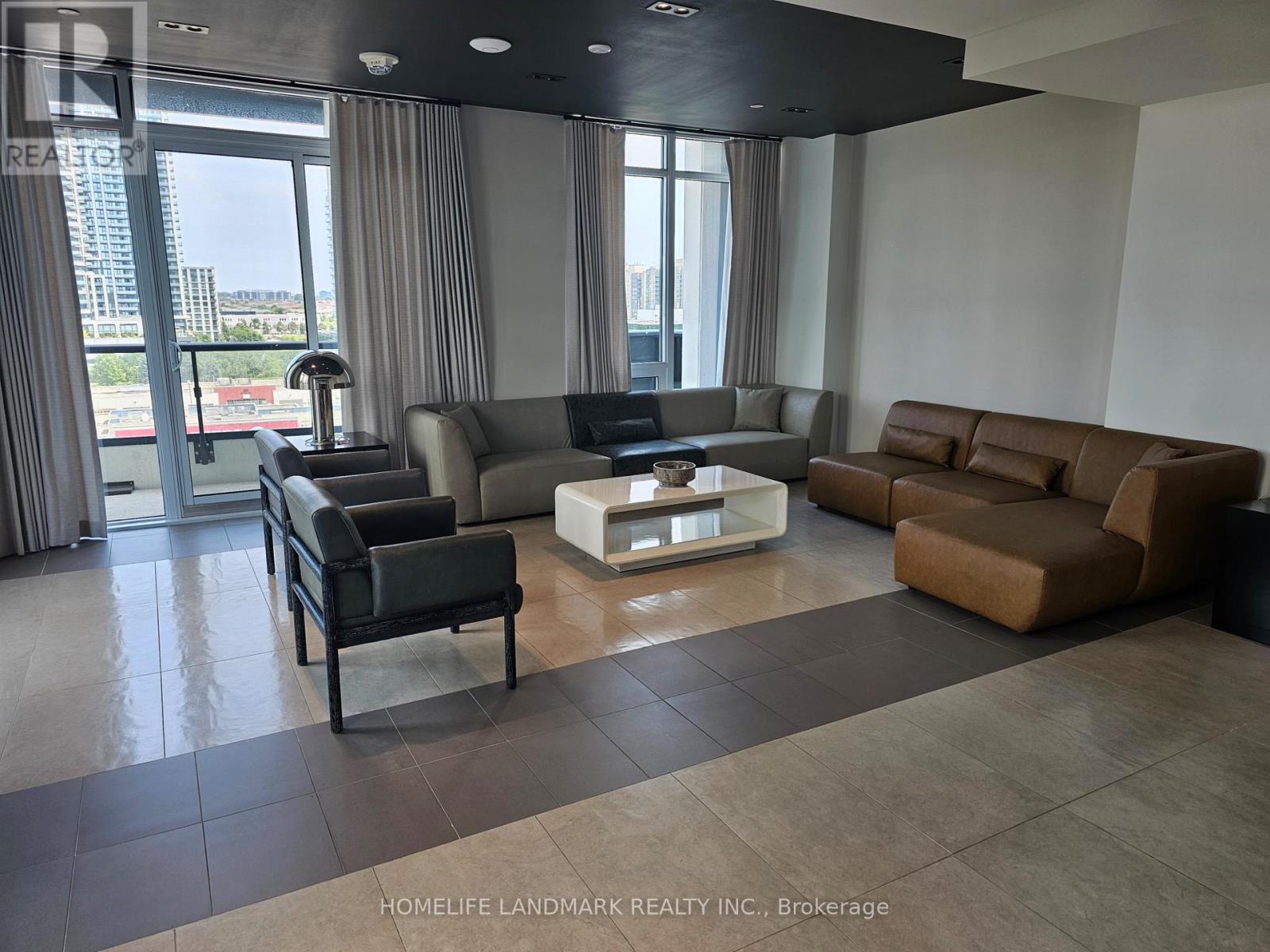 A living room with a black leather chair and a white coffee table.