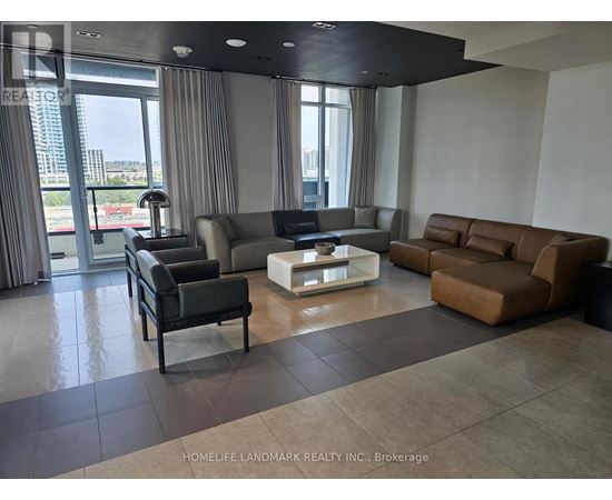 A living room with a black leather chair and a white coffee table.