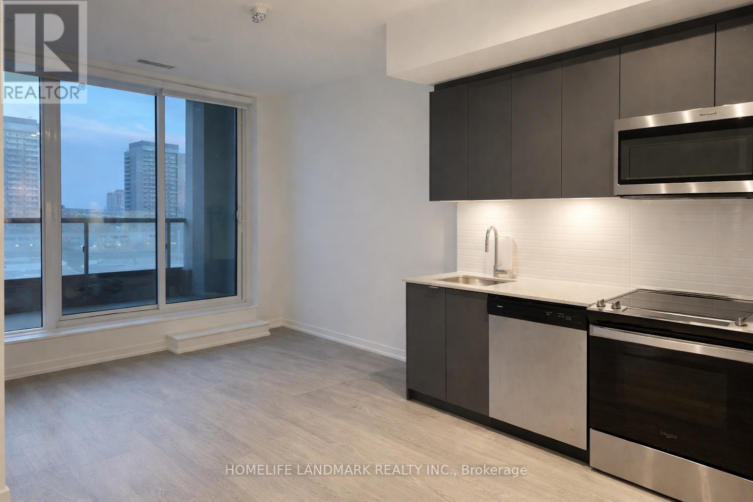 A modern kitchen with dark wood cabinets and stainless steel appliances.