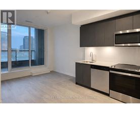 A modern kitchen with dark wood cabinets and stainless steel appliances.