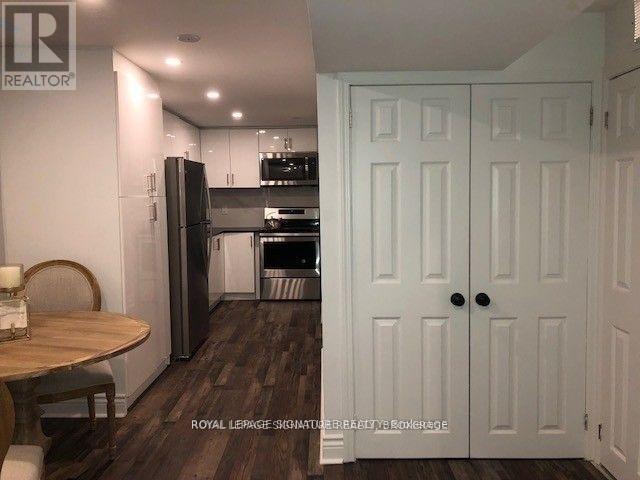 A kitchen with a table and chairs in front of a refrigerator.