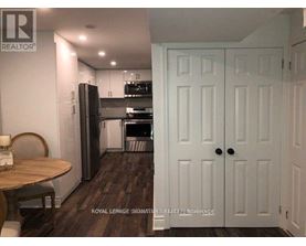 A kitchen with a table and chairs in front of a refrigerator.
