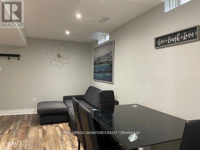 A living room with a black couch and a glass table.