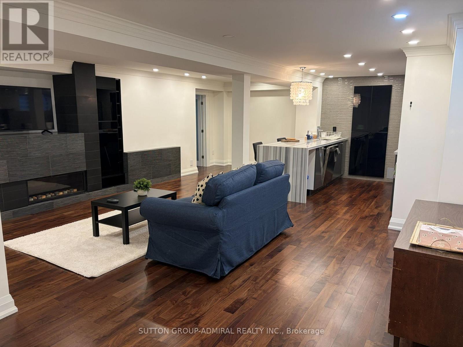 A living room with a blue couch and a fireplace.