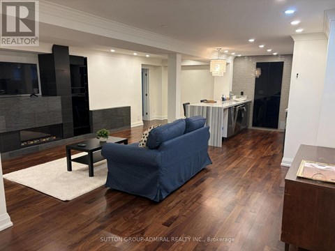 A living room with a blue couch and a fireplace.
