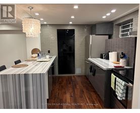 A modern kitchen with a dining table and a refrigerator.