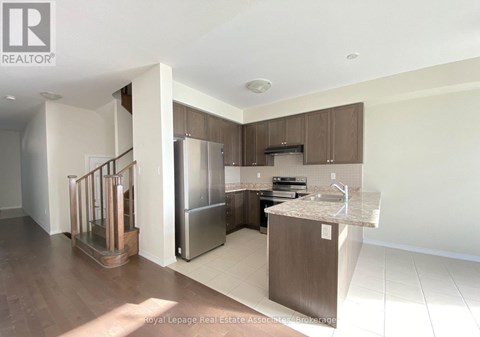 A modern kitchen with a refrigerator, sink, and cabinets.