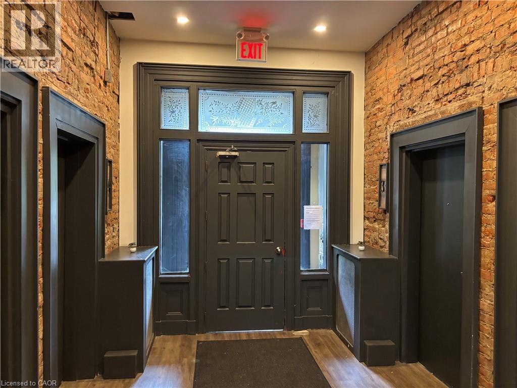 A black door with a glass window is flanked by two black speakers.