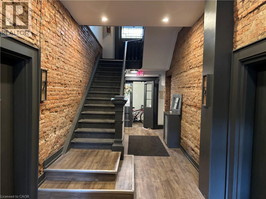 A staircase with a black metal railing and wooden steps.