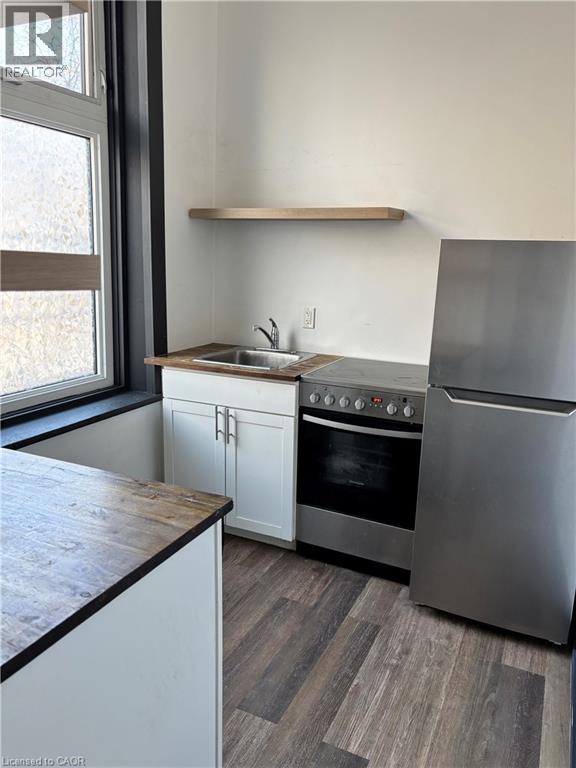 A modern kitchen with a stainless steel refrigerator, oven, and sink.
