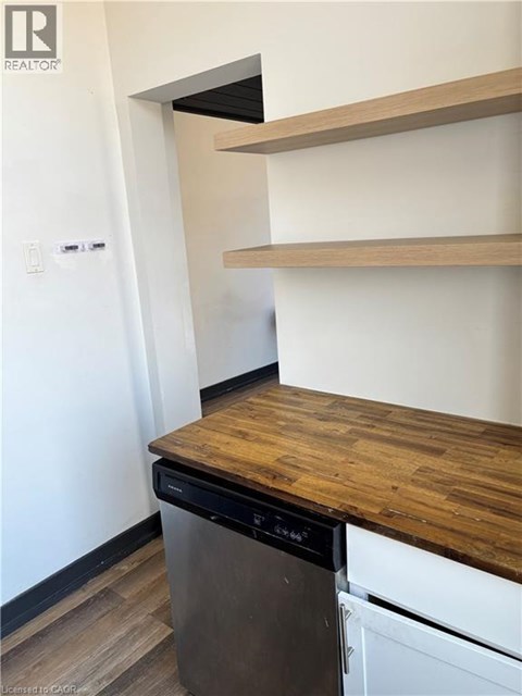 A kitchen with a dishwasher and a wooden counter top.