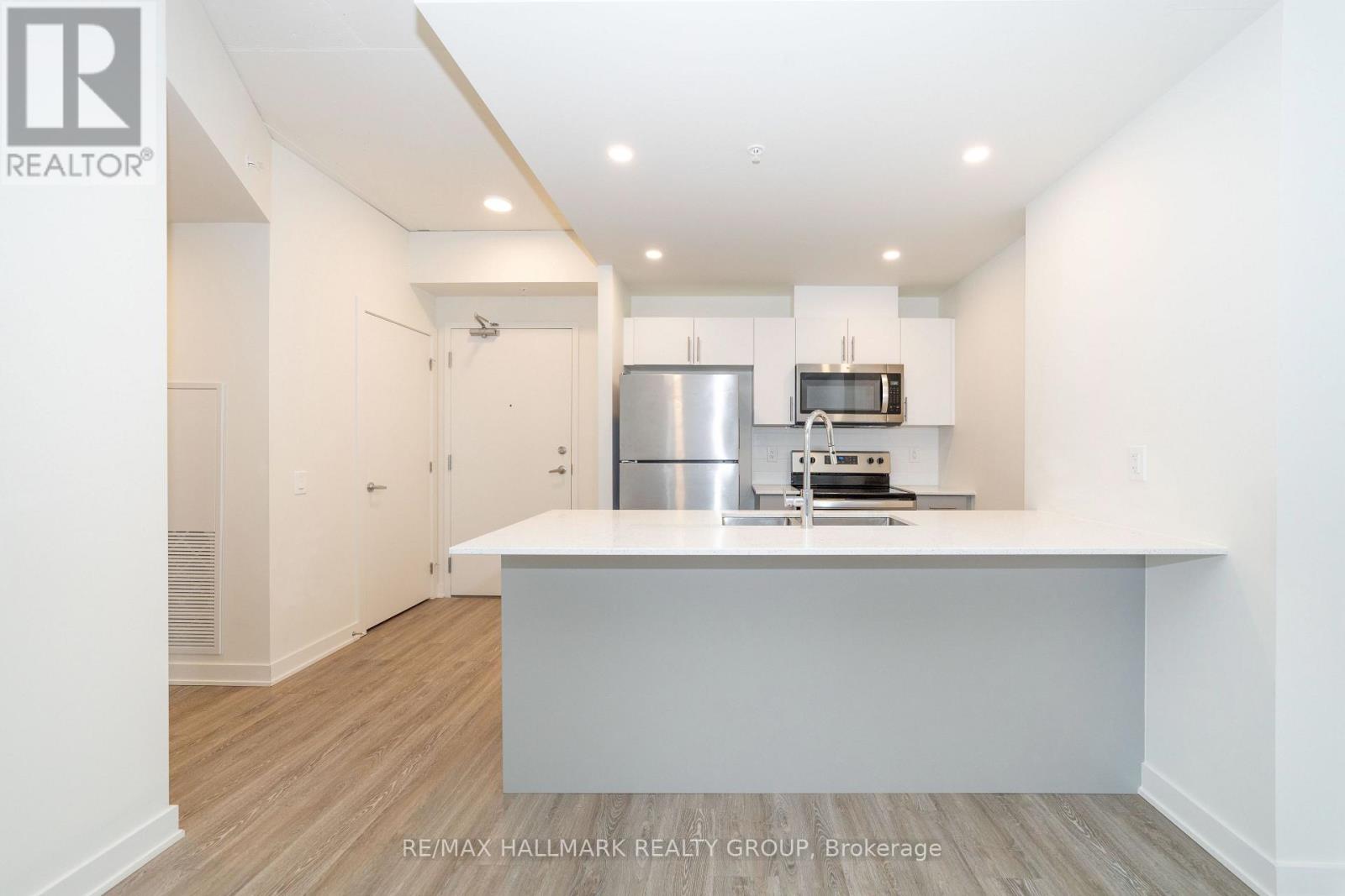 A kitchen with white cabinets and a stainless steel refrigerator.