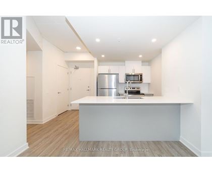 A kitchen with white cabinets and a stainless steel refrigerator.