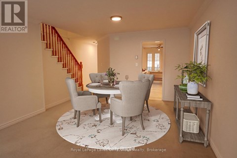 A dining room with a round table and chairs.
