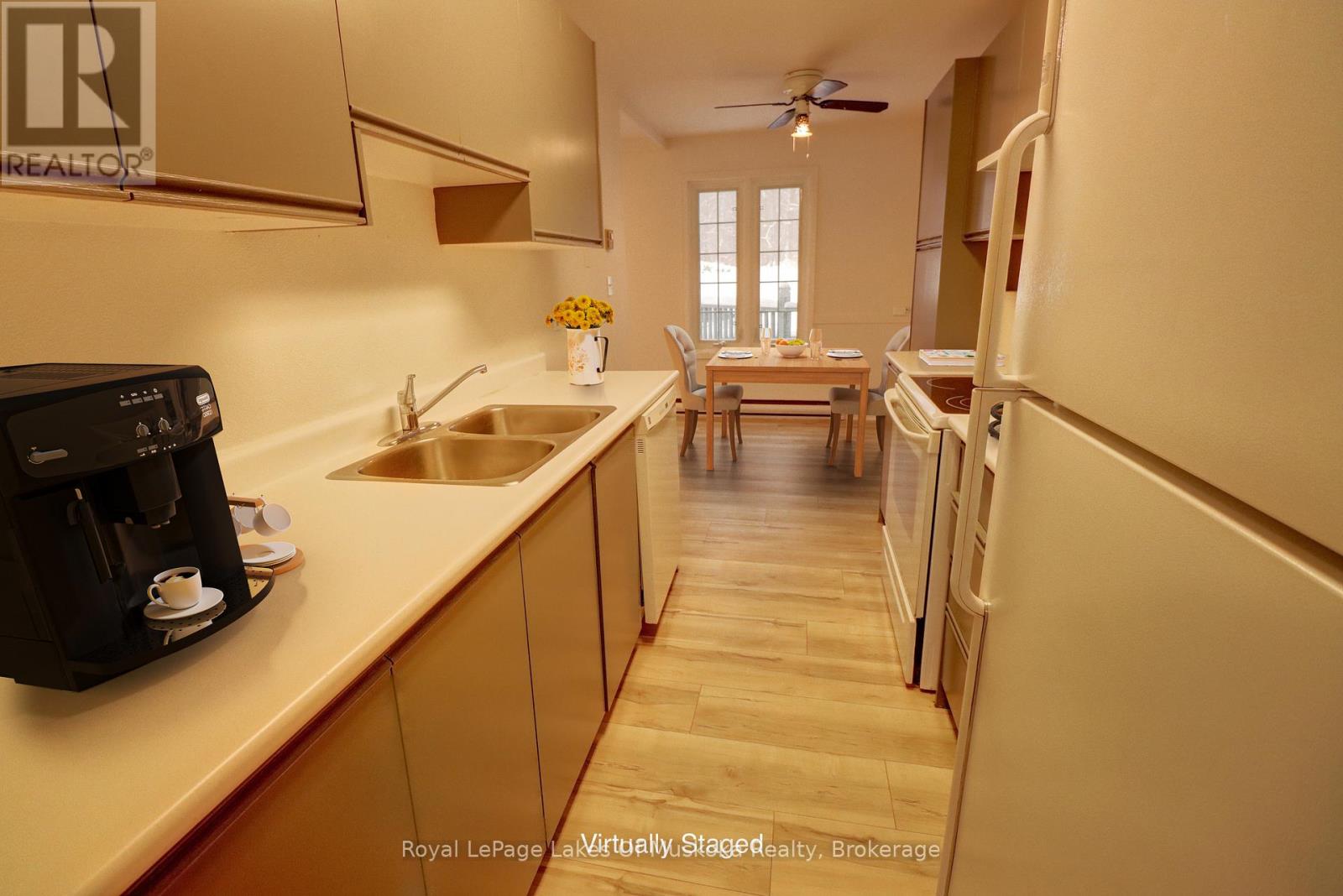 A kitchen with a sink, a coffee maker, and a dining table.