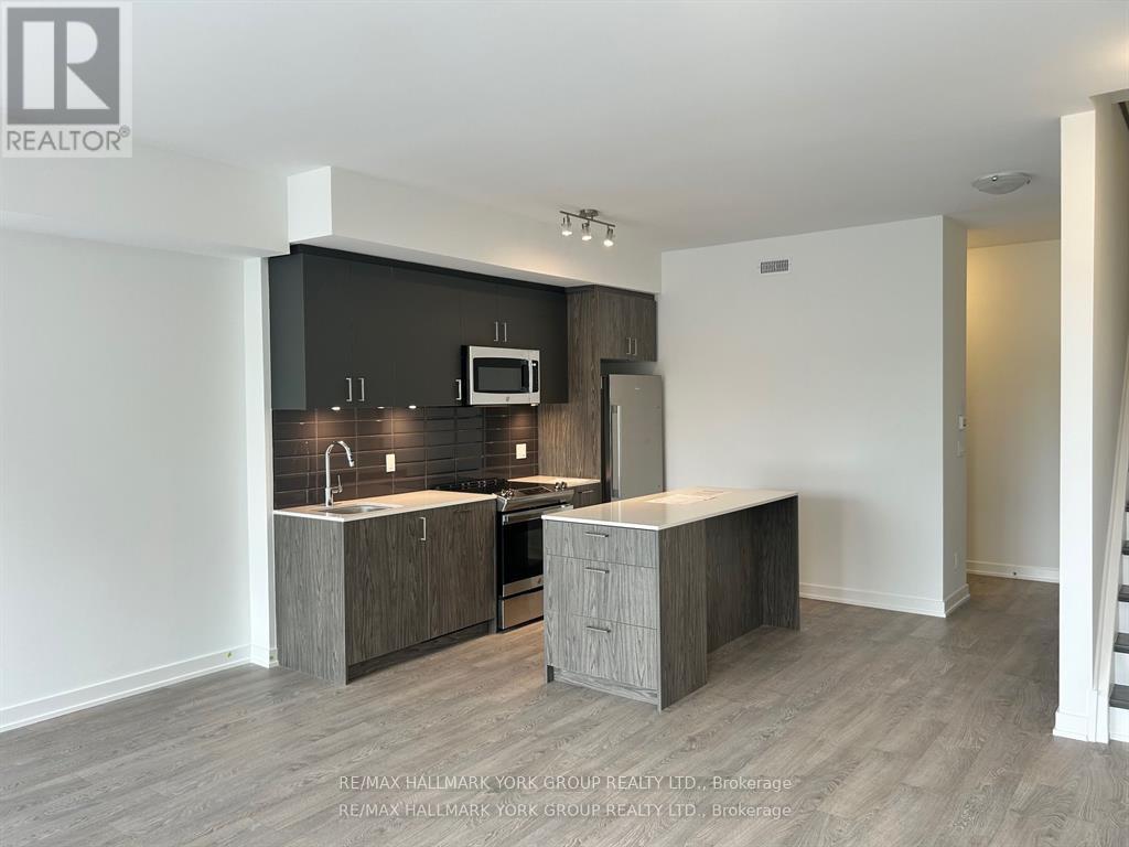 A modern kitchen with a sink, microwave, and oven.