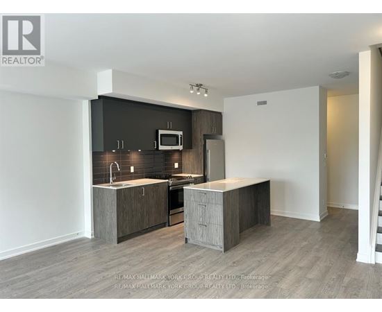 A modern kitchen with a sink, microwave, and oven.