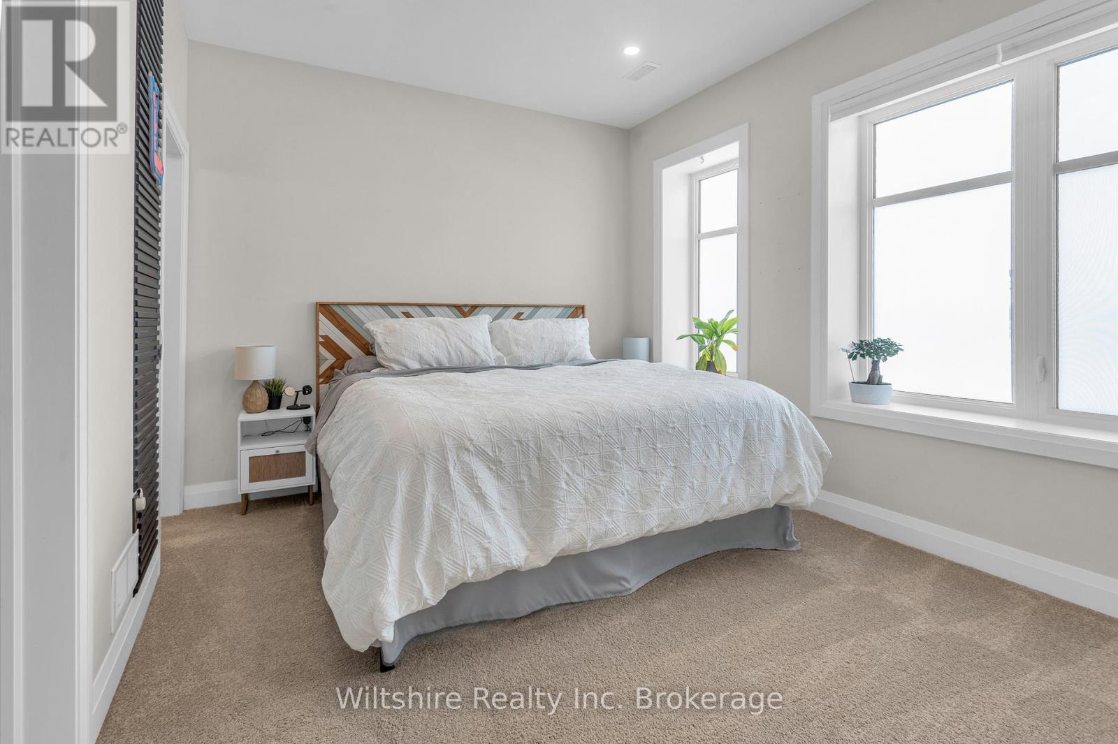 A bedroom with a large bed and a window.