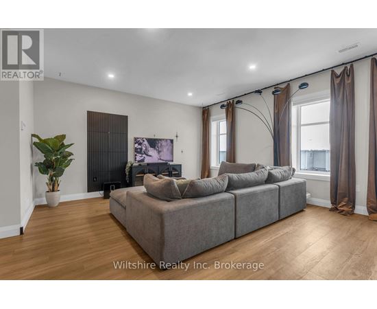 A living room with a grey couch and a plant.