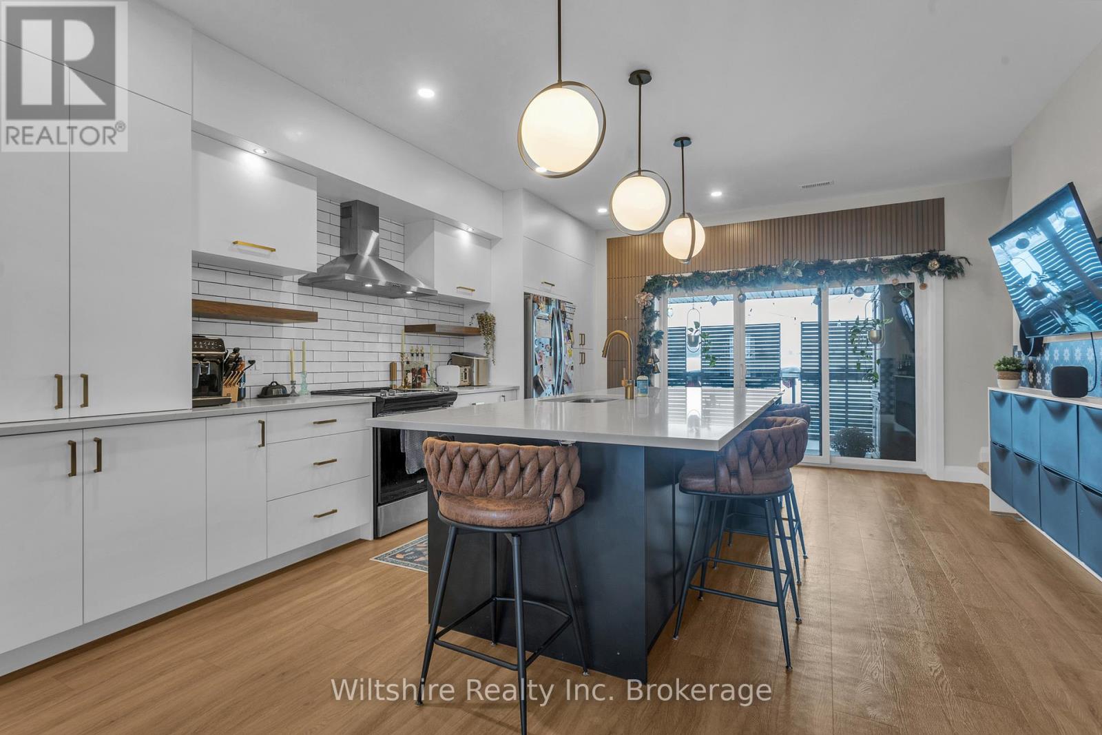 A modern kitchen with a large island and bar stools.