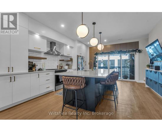 A modern kitchen with a large island and bar stools.