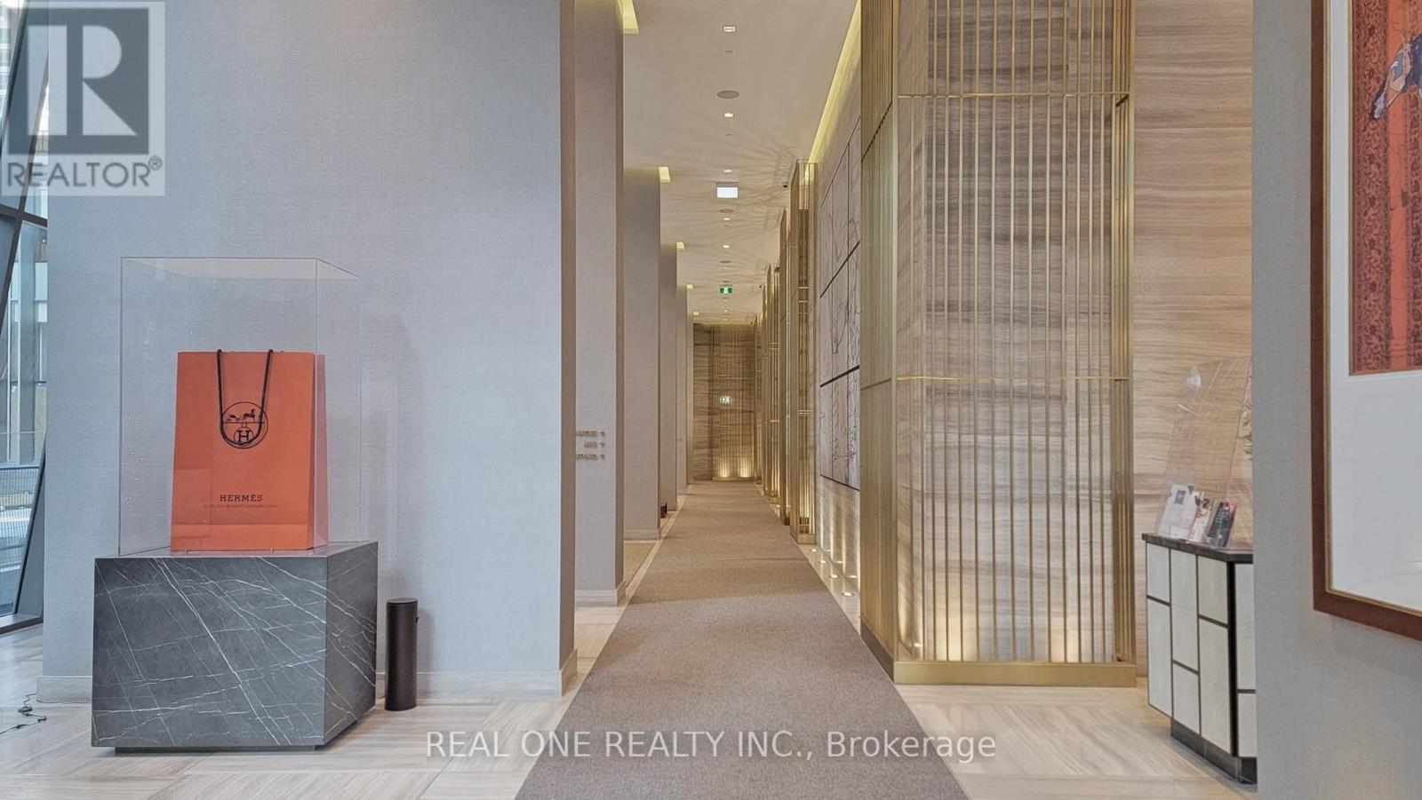 A hallway with a sign that says Real One Realty Inc. Brokerage.