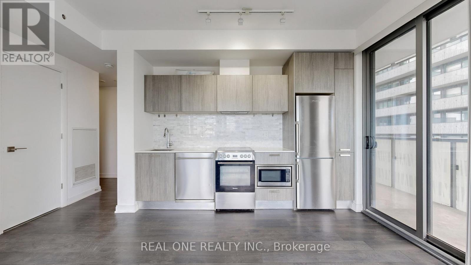 A modern kitchen with a stainless steel refrigerator and oven.