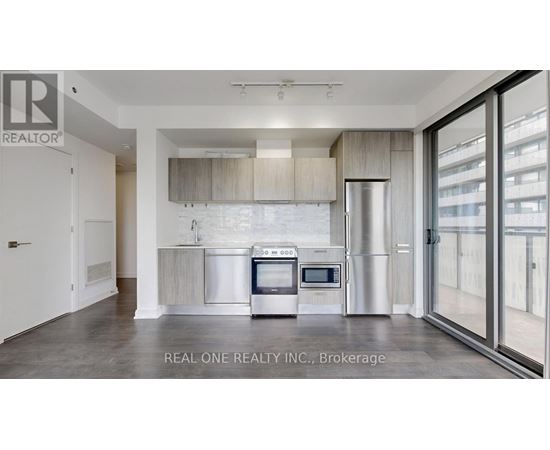 A modern kitchen with a stainless steel refrigerator and oven.