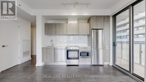 A modern kitchen with a stainless steel refrigerator and oven.