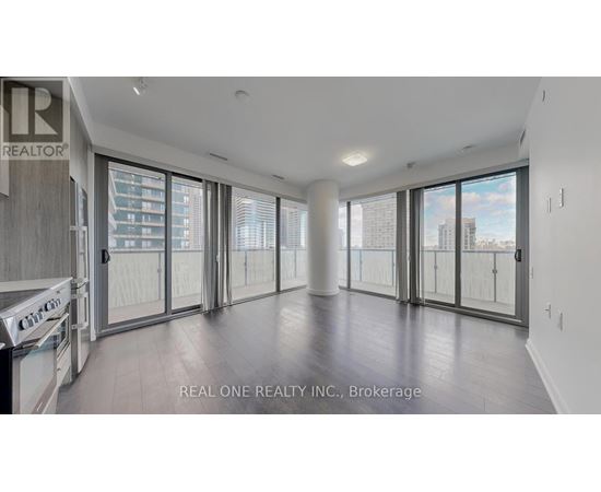 A spacious, empty room with large windows and sliding glass doors.