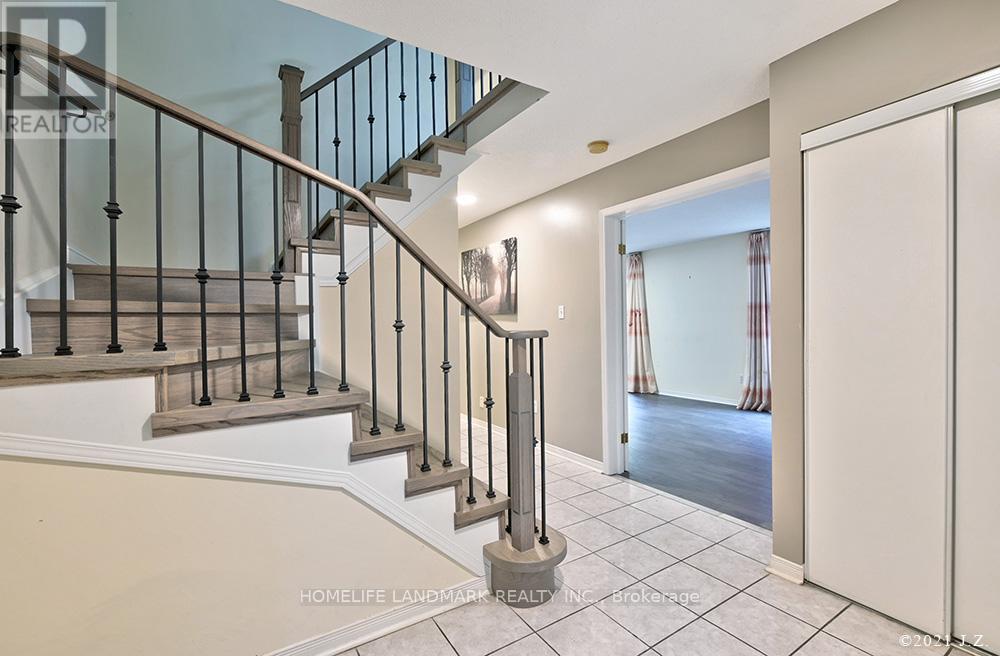 A staircase with a metal railing and a round column in the middle of the room.