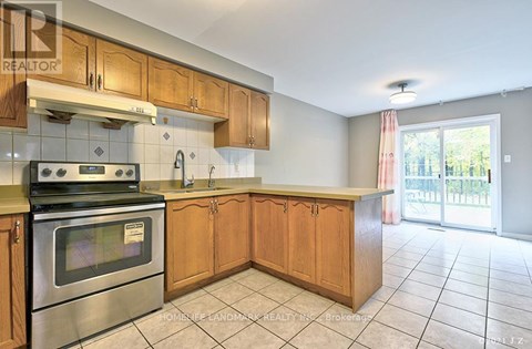 A kitchen with wooden cabinets and a stainless steel oven.