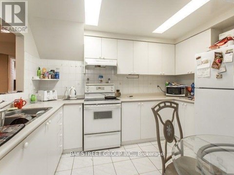 A kitchen with white cabinets and appliances.
