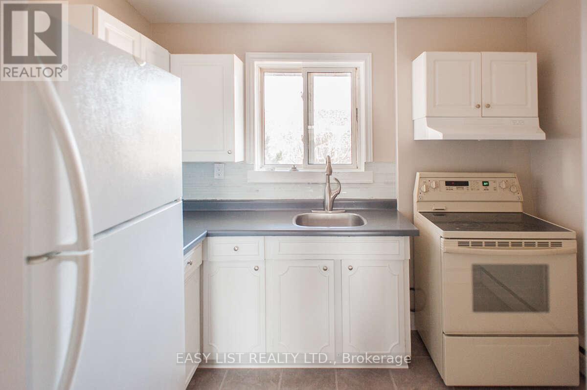 A small kitchen with white appliances and cabinets.
