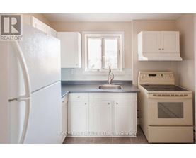 A small kitchen with white appliances and cabinets.