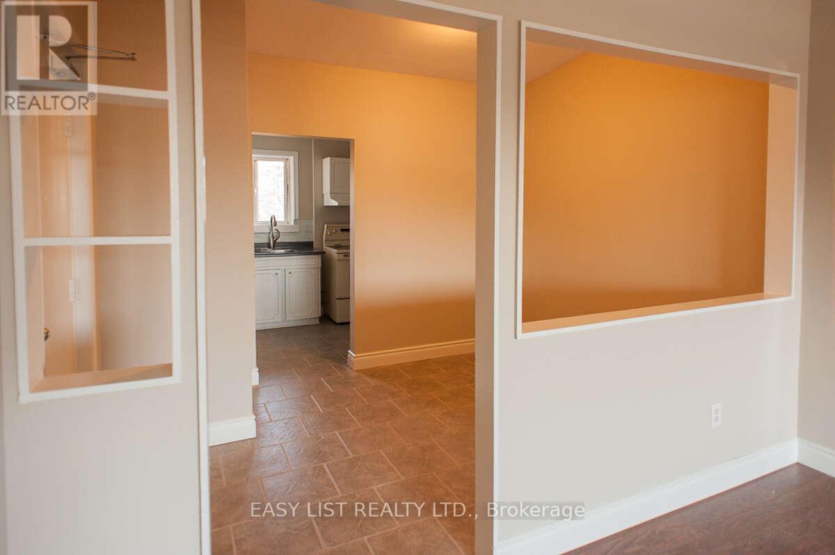 A room with a tiled floor and a white door leading to another room.