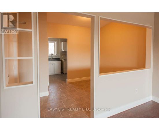 A room with a tiled floor and a white door leading to another room.