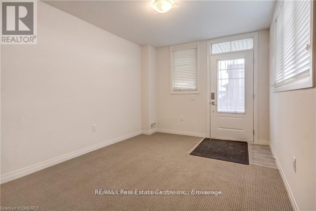 A room with a door, a window with blinds, and a carpet on the floor.