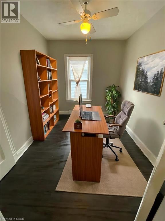 A room with a desk, chair, and bookshelf.