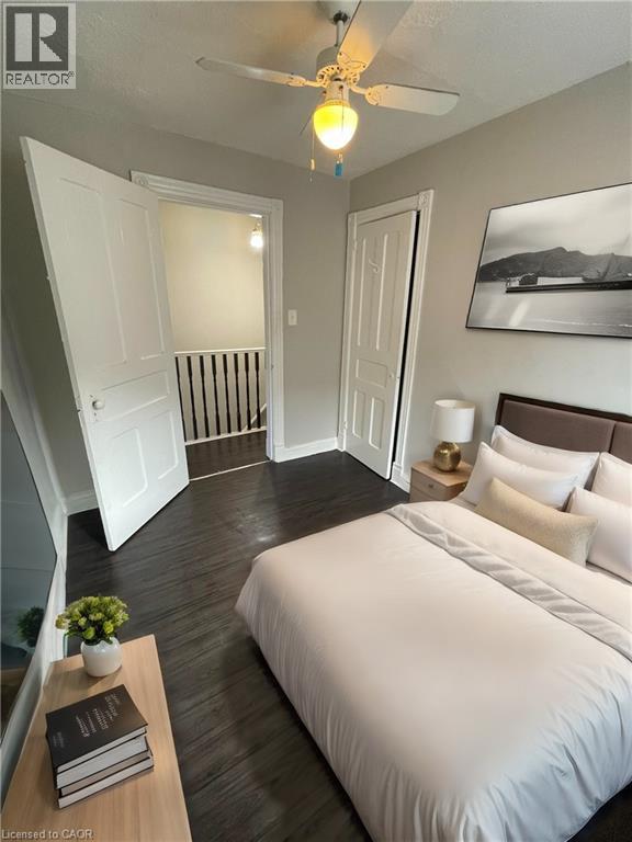 A bedroom with a bed, nightstand, and a plant on a table.