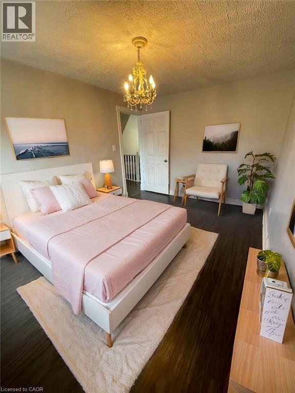 A bedroom with a large bed and a chandelier.
