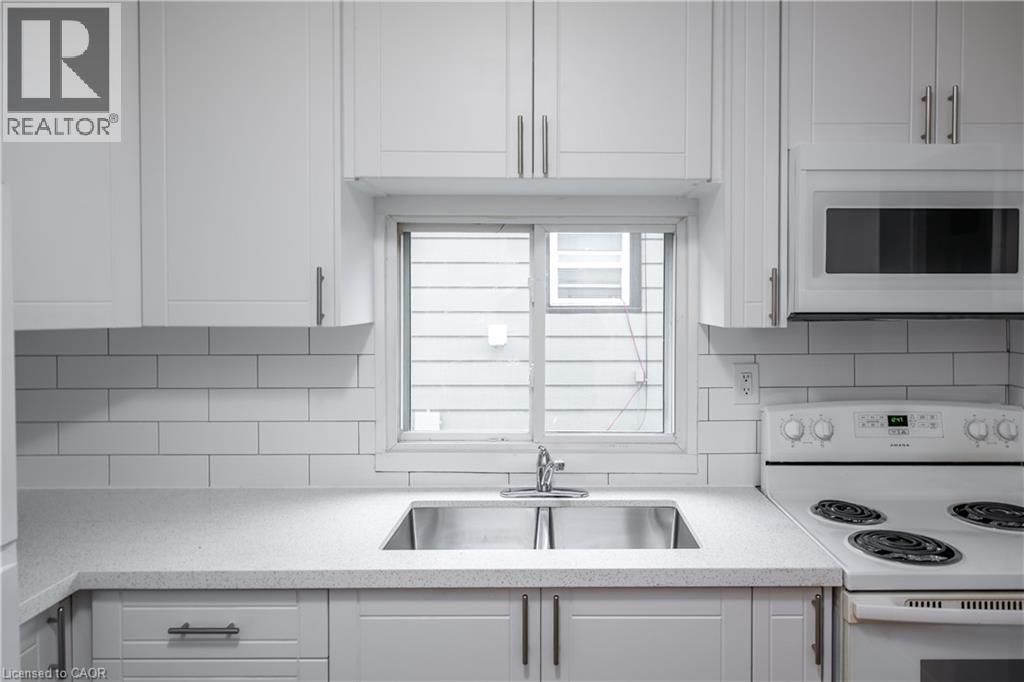 A white kitchen with a sink and stove.